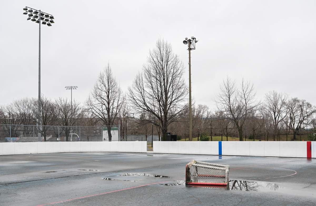 A goalie net is shown in a puddle of water on a hockey rink in Montreal, Thursday, December 28, 2023, as mild weather continues in the region.