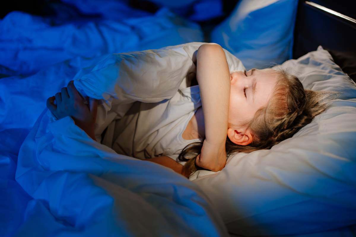 The little girl is sick, lies in bed and coughs. caring for children. restless sleep during illness. cough medicine.