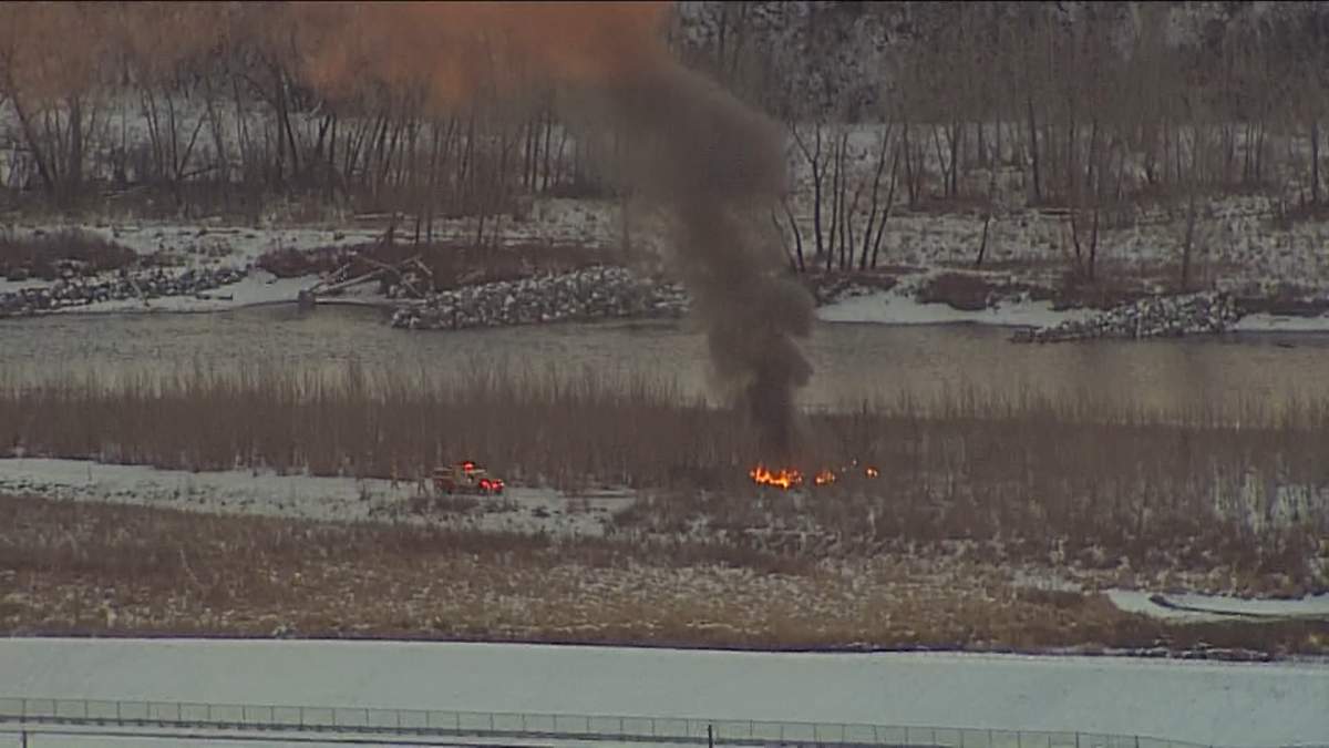 Flames in the brush on the west side of the Bow River in southeast Calgary during a CFD response to a fire at a homeless camp.