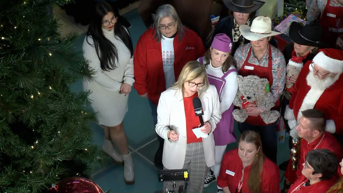 Global Calgary’s Leslie Horton stands with Santa Claus and Morning of Giving volunteers.