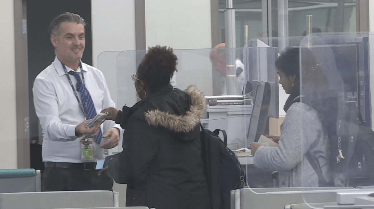 A man hands a woman her passport.