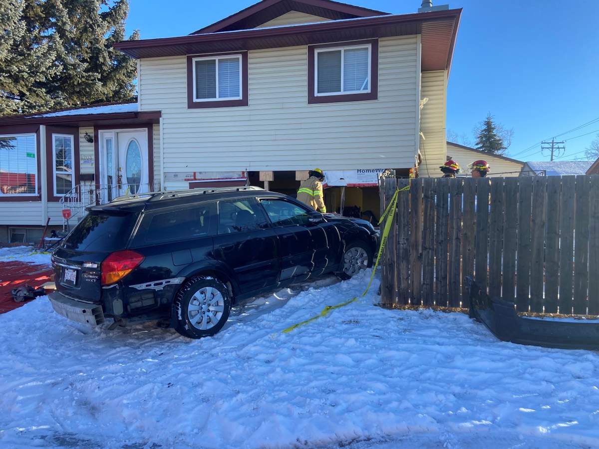 Calgary Fire Department crews at the scene of the crash where police say a stolen vehicle damaged a home in Whitehorn on Tuesday morning.