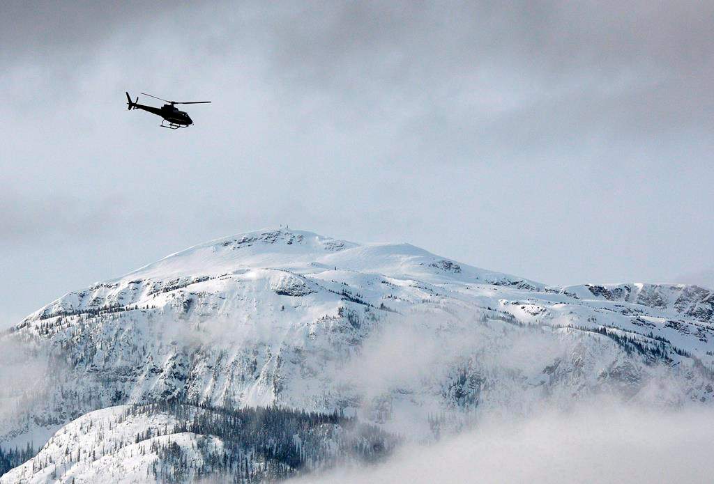FILE - A search and rescue helicopter heads toward an avalanche site in a March 14, 2010 photo near Revelstoke, B.C.