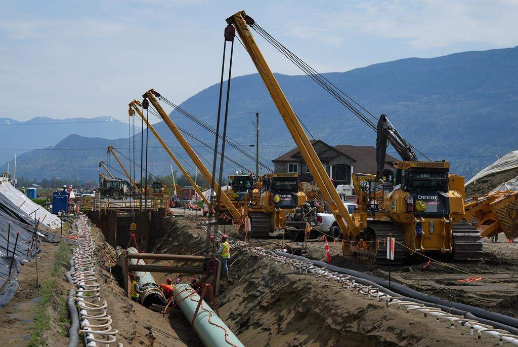 Workers lay pipe during construction of the Trans Mountain pipeline expansion, in Abbotsford, B.C., on Wednesday, May 3, 2023. The Canada Energy Regulator is slated to hear oral arguments Friday from the company building the Trans Mountain pipeline expansion on its request for a pipeline variance.THE CANADIAN PRESS/Darryl Dyck