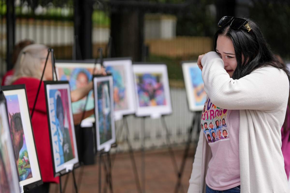 Natalie Carson cries at a memorial for the victims of the Uvalde school shooting at the Governor's Mansion in Austin, Texas, on Wednesday May 24, 2023. Dozens of people gathered to remember the children and teachers on the one year anniversary of the shooting.