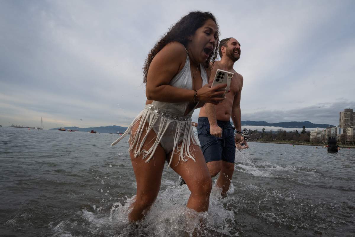 People participate in the Polar Bear Swim on New Year’s Day at English Bay Beach in Vancouver, B.C., Monday, Jan. 1, 2024. THE CANADIAN PRESS/Ethan Cairns