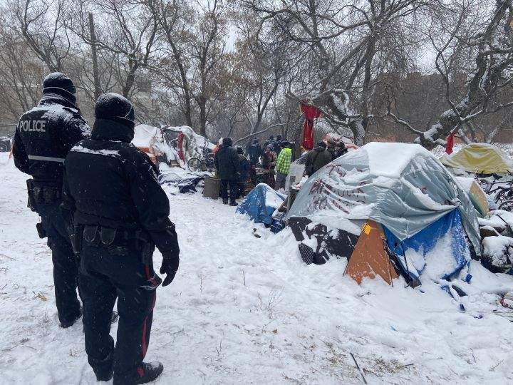 Edmonton police officers and city crews could be seen at a homeless encampment in the area of 95th Street and Rowland Road on Tuesday morning. Police and cleanup crews were met with resistance from people who live in the camp and from advocates who showed up to support them.