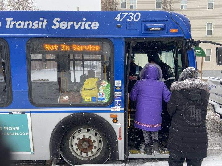 Some residents of a central Edmonton homeless encampment board a bus on Jan. 9, 2024 after the camp was ordered to be removed. The city said shelter space was available for encampment residents.