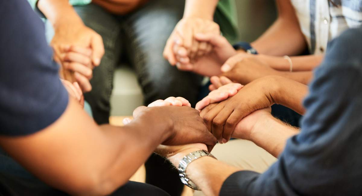 Peoplae holding hands together during a religious group gathering