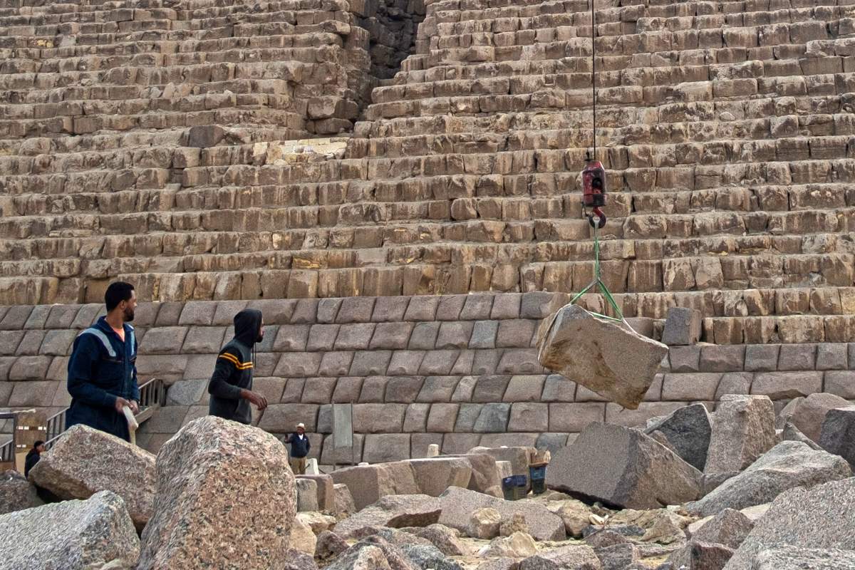 A granite boulder is lifted via a crane.