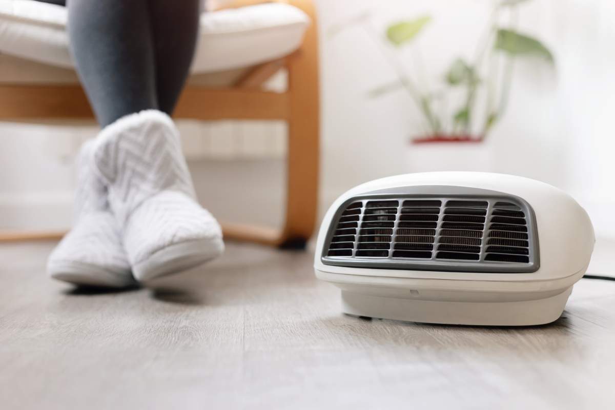 woman sitting near space heater