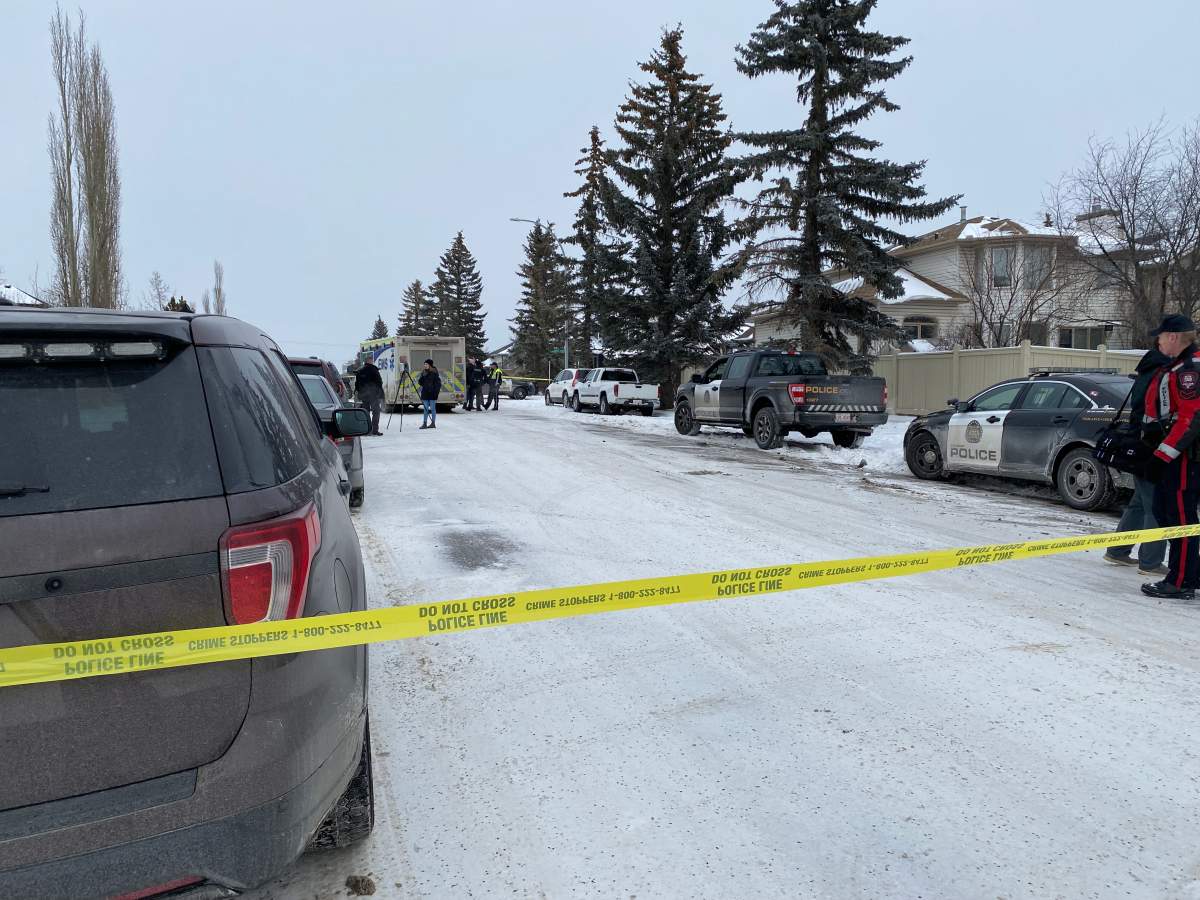 Calgary police surround a vehicle they were looking for, in relation to a homicide investigation in the Strathcona Park neighbourhood, on Jan. 16, 2024.