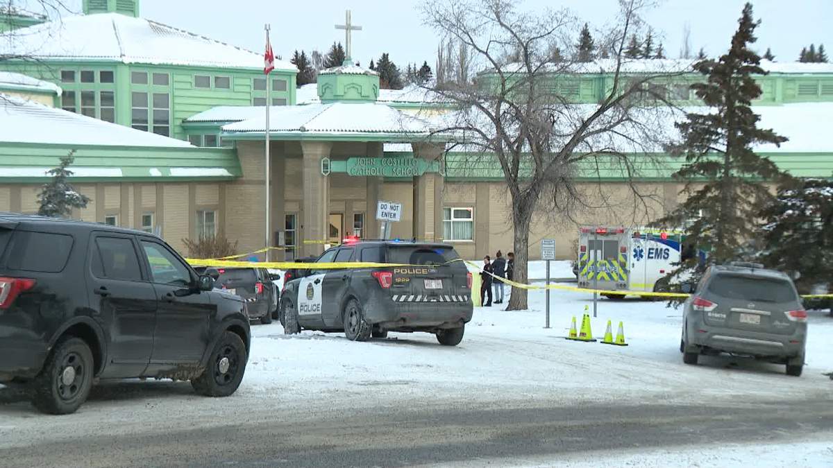 Calgary Police Service vehicles and tape are seen in front of John Costello Catholic School on Jan. 16, 2024.