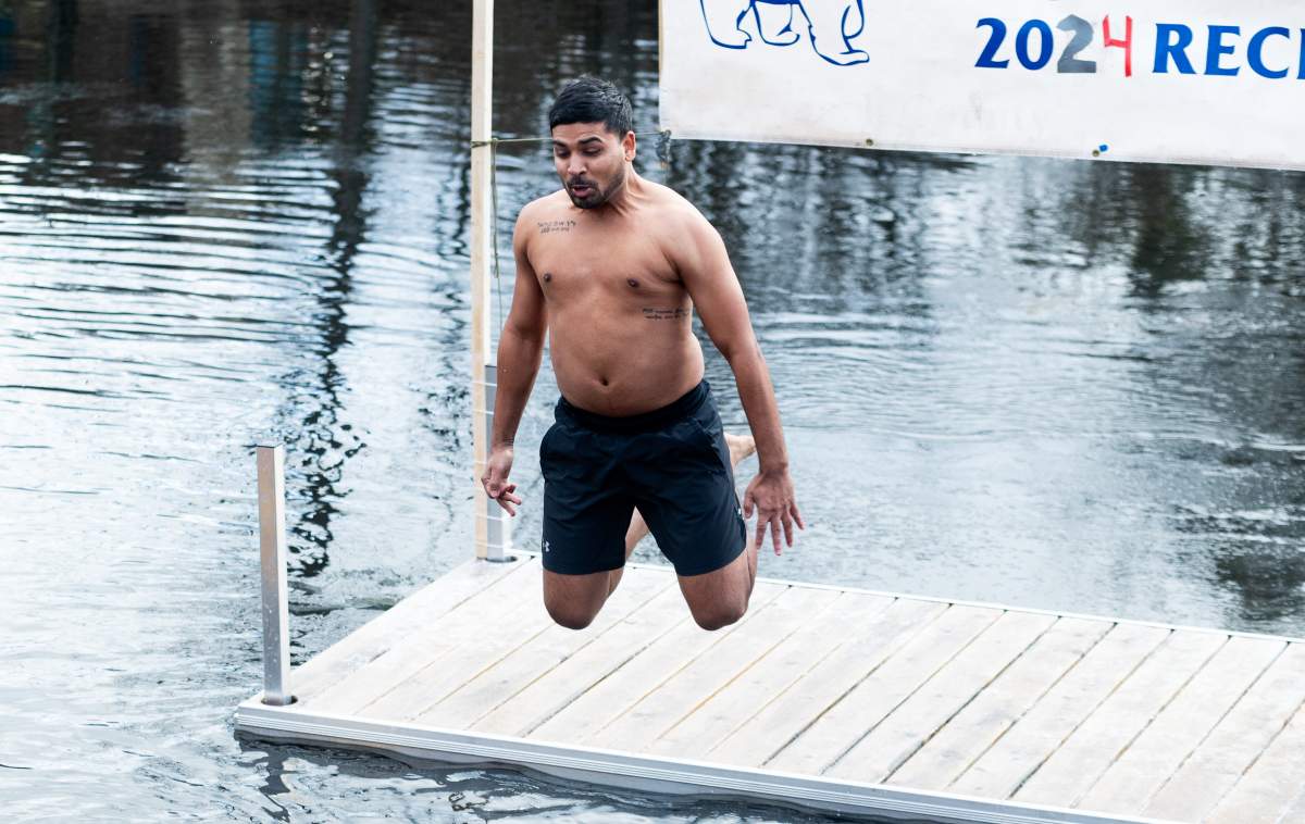 A Polar Bear plunger rings in the New Year with a jump into the Tay River on the 30th Anniversary of the Perth Polar Bear Plunge in Perth, Ont. on Monday, Jan. 1, 2024.