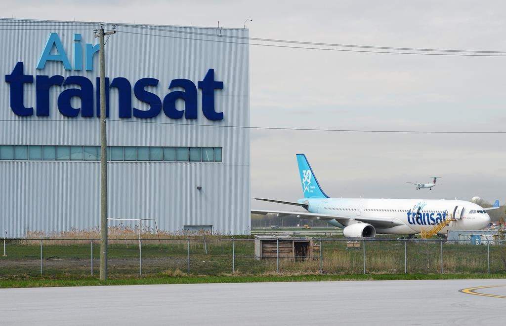 An Air Transat plane is seen as an Air Canada plane lands at Pierre Elliott Trudeau International Airport in Montreal on Thursday, May 16, 2019.