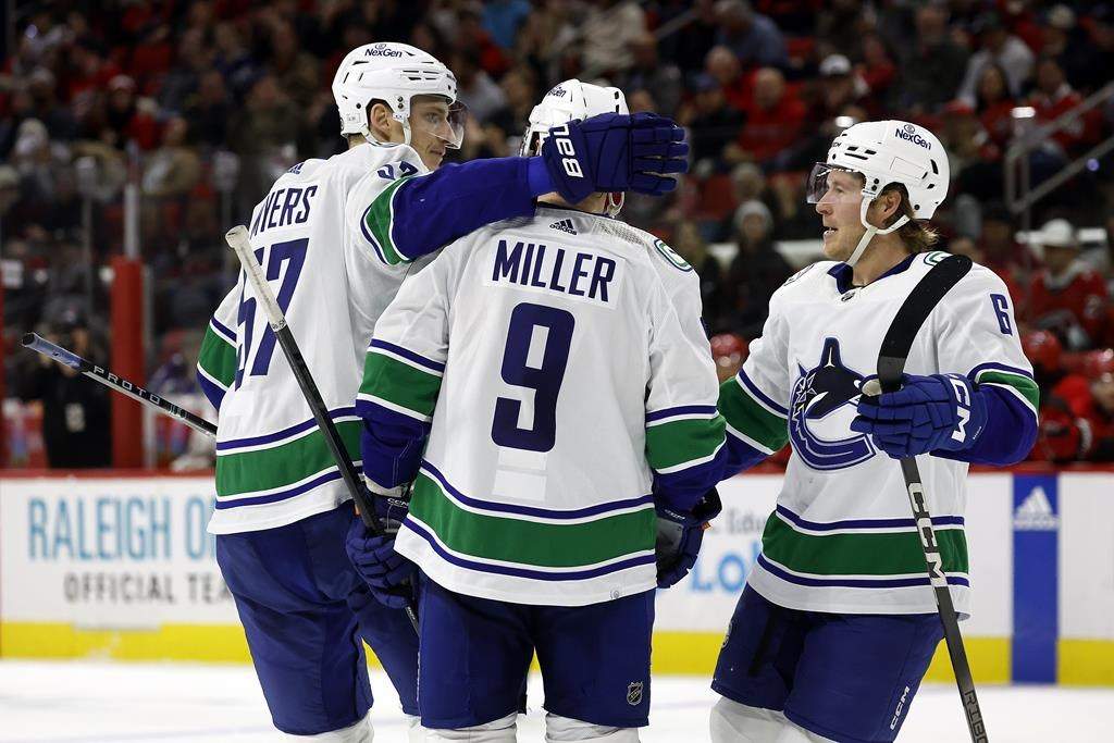 Vancouver Canucks’ J.T. Miller (9) is congratulated by Tyler Myers (57) and Brock Boeser (6) for his goal during the third period of the team’s game against the Carolina Hurricanes in Raleigh, N.C. on Tuesday.
