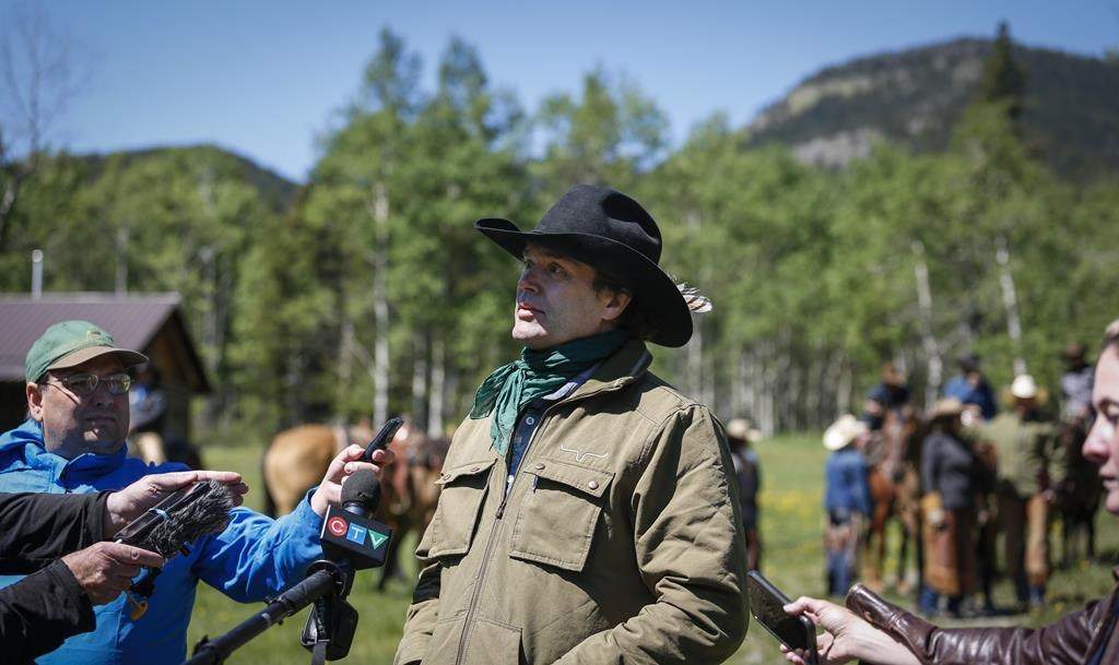 Singer Corb Lund, centre, speaks to media on land proposed for coal mine development in the eastern slopes of the Livingstone range southwest of Longview, Alta., Wednesday, June 16, 2021. 
