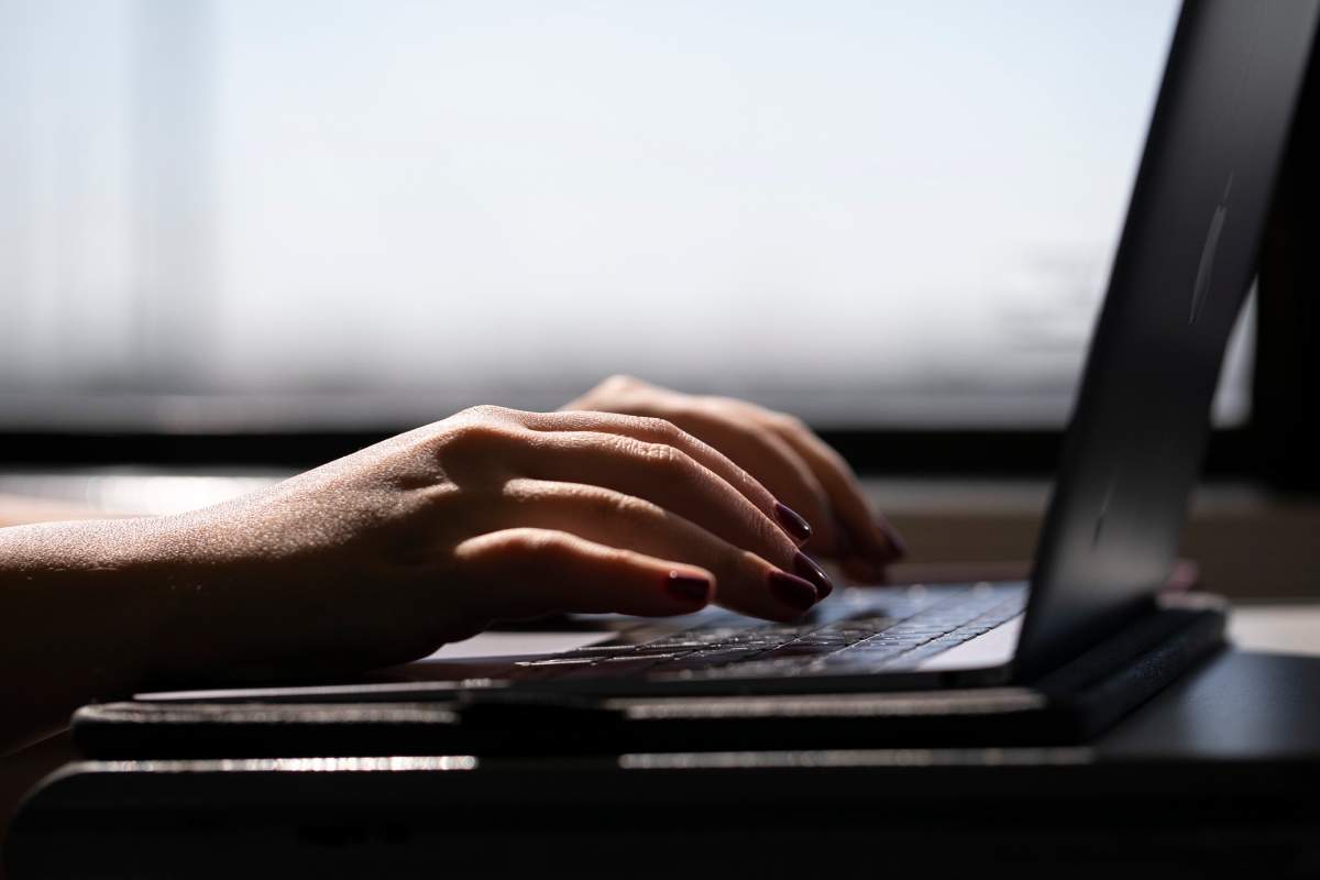 FILE: A woman types on a laptop on a train in New Jersey on May 18, 2021.