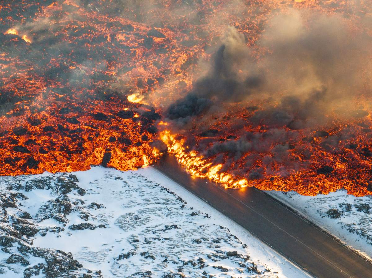 A view of lava crossing the main road to Grindavík and flowing on the road leading to the Blue Lagoon, in Grindavík, Iceland, Thursday, Feb. 8, 2024.