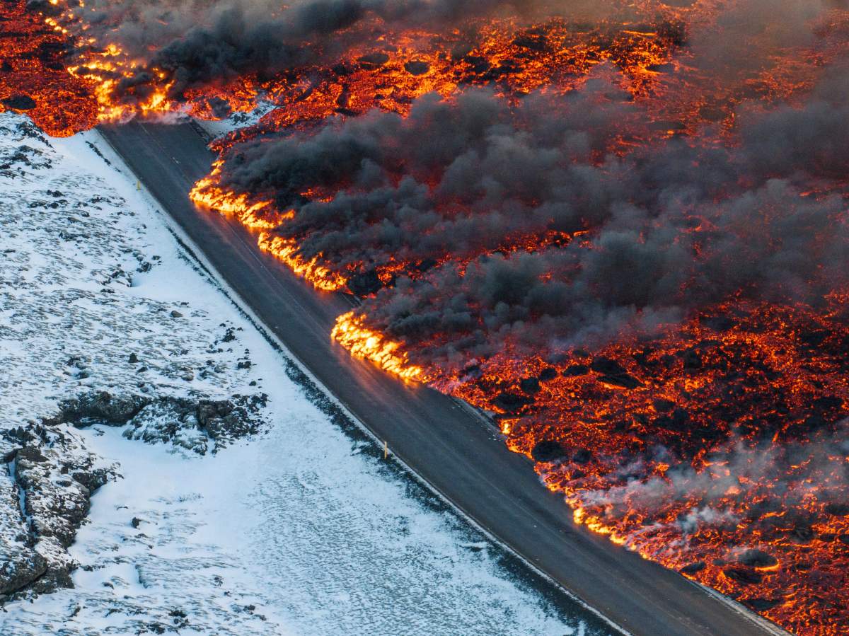 A view of lava crossing the main road to Grindavík and flowing on the road leading to the Blue Lagoon, in Grindavík, Iceland, Thursday, Feb. 8, 2024.