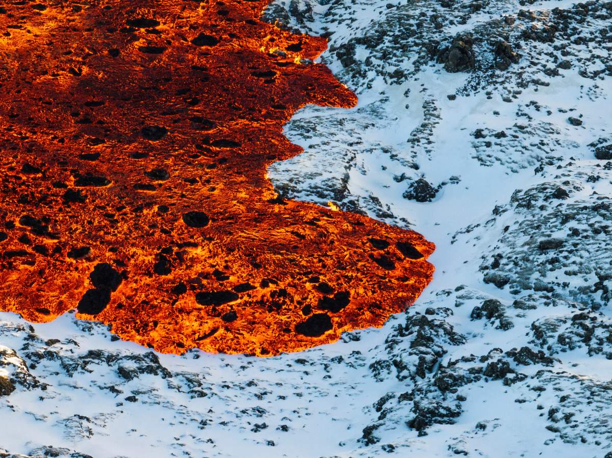 A view of lava crossing the main road to Grindavík and flowing on the road leading to the Blue Lagoon, in Grindavík, Iceland, Thursday, Feb. 8, 2024.