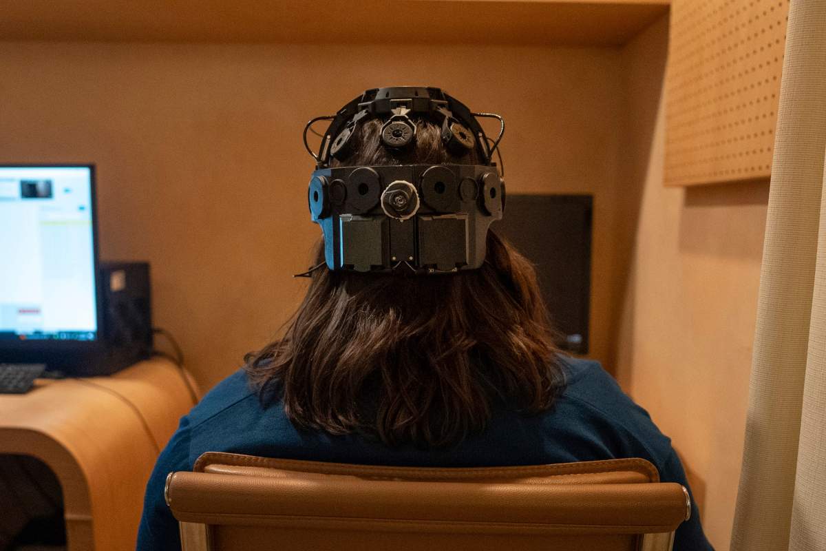 Emily Hollenbeck, a deep brain stimulation therapy patient, demonstrates an EEG device that records brain activity as she reacts to short videos at Mount Sinai’s “Q-Lab” in New York on Dec. 20, 2023. Dr. Brian Kopell, who directs Mount Sinai's Center for Neuromodulation, says in normal brains electrical activity reverberates unimpeded in all areas, in a sort of dance. In depression, the dancers get stuck within the brain’s emotional circuitry. DBS seems to “unstick the circuit,” he says, allowing the brain to do what it normally would. (AP Photo/Mary Conlon)