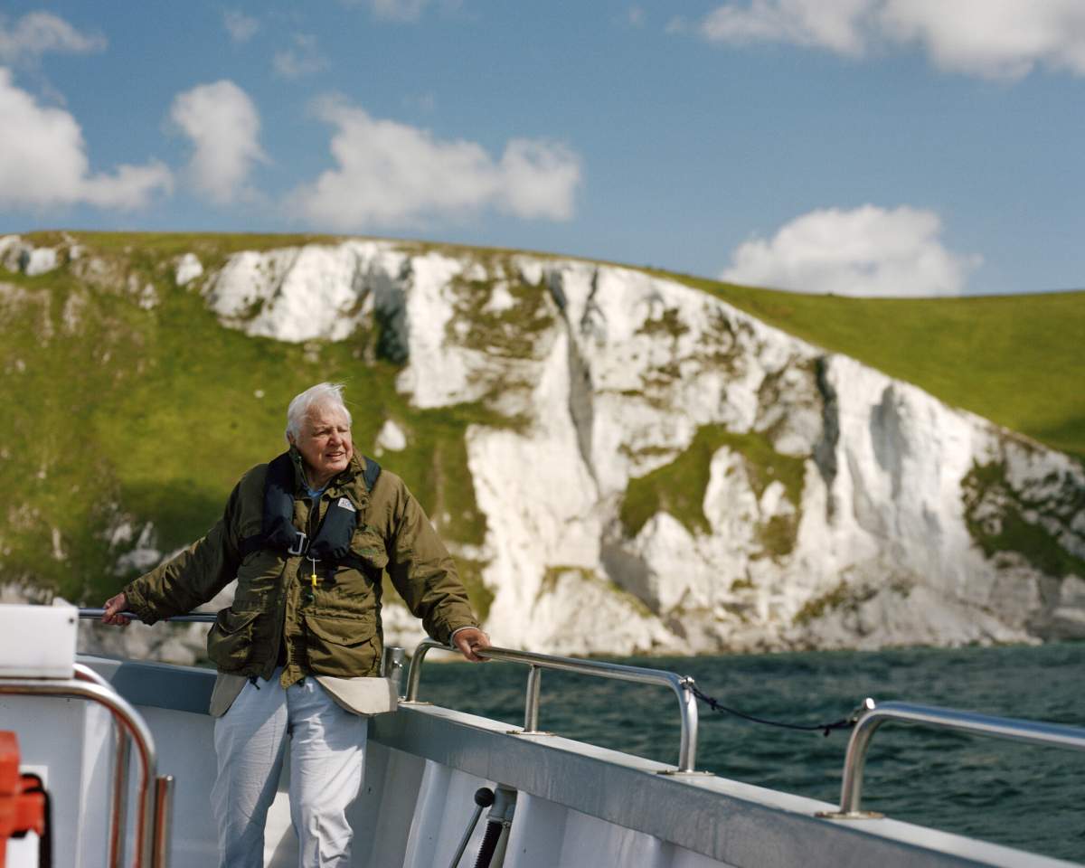 David Attenborough onboard a boat while filming near White Nothe cliffs, on the Jurassic Coast, Dorset, UK.