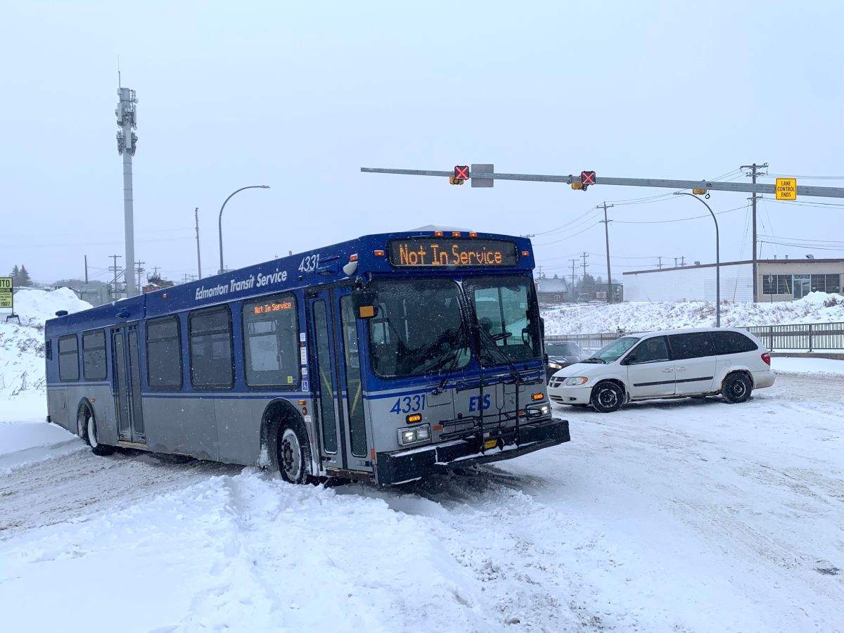 A city bus is seen in the area of 127th Street and 127th Avenue in Edmonton on Monday morning. The bus was struggling to move after a heavy snowfall and a tow truck was called to the area.