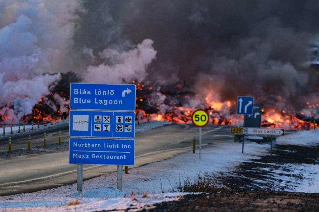 Molten lava is seen overflowing the road leading to the famous tourist destination Blue Lagoon near Grindavik, western Iceland on February 8, 2024.