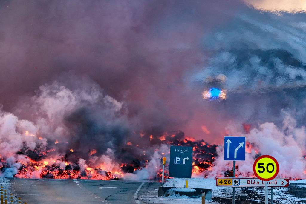 Molten lava is seen overflowing the road leading to the famous tourist destination "Blue Lagoon" near Grindavik, western Iceland on February 8, 2024.