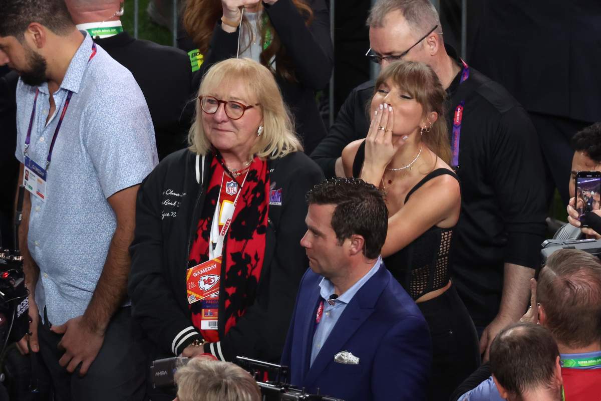 Taylor Swift blows a kiss while standing next to Donna Kelce.