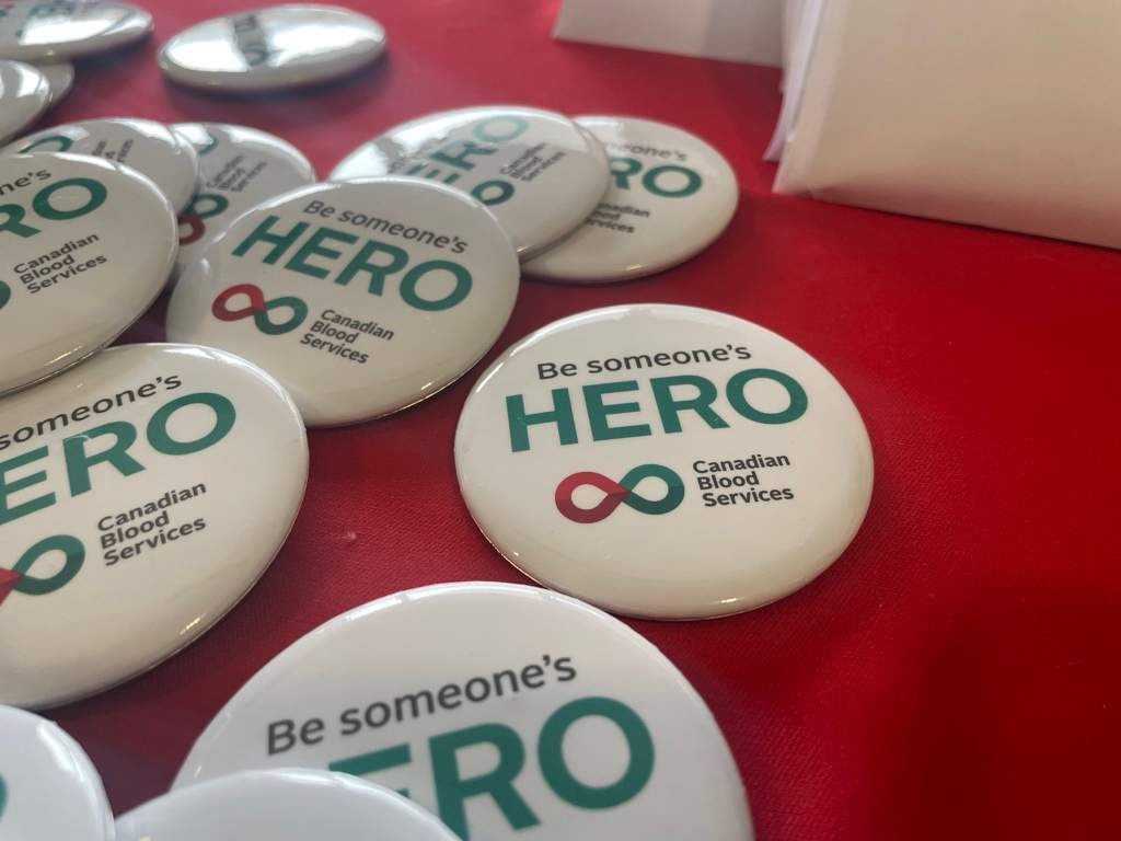 “Be someone’s hero” is written on pins laid across a Canadian Blood Services registration desk at Dalhousie University on Friday.