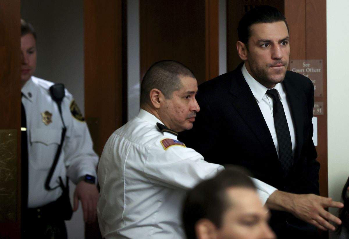 Boston Bruins forward Milan Lucic, top right, is escorted by a court officer, Tuesday, Nov. 21, 2023, as he enters a courtroom at Boston Municipal Court, in Boston, for his arraignment on an assault charge in connection with his arrest over the weekend after his wife called police to their home and said he tried to choke her. Lucic has been released on personal recognizance bail after pleading not guilty to assaulting his wife.