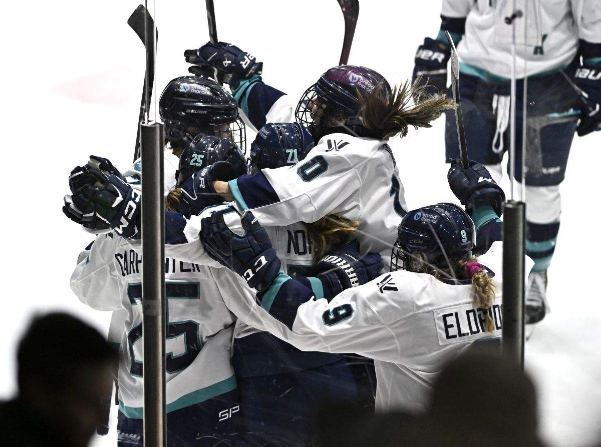New York's Kayla Vespa (10) leaps onto teammates as they celebrate the game winning goal of Alex Carpenter (25), left, in overtime PWHL hockey action against Ottawa in Ottawa, on Sunday, Feb. 4, 2024.