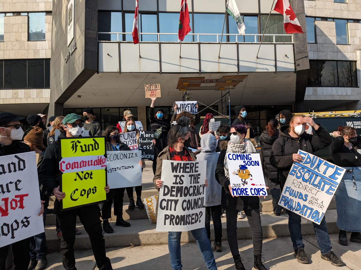 People holding signs outside of city hall.