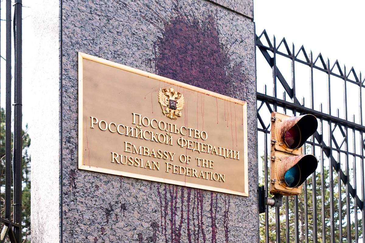 The Russian Embassy sign is vandalized with a red liquid substance by a passerby wearing a mask, Friday, Feb. 16, 2024, in Washington. The vandalism happened after Alexei Navalny, who crusaded against official corruption and staged massive anti-Kremlin protests as President Vladimir Putin’s fiercest foe, died in the Arctic penal colony where he was serving a 19-year sentence. He was 47. (AP Photo/Manuel Balce Ceneta)