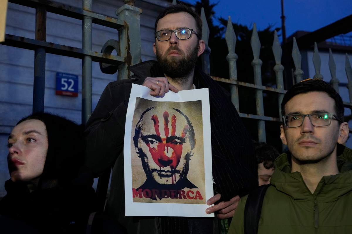A man holds a poster showing Russia’s leader, Vladimir Putin with blood on his hands during a gathering before the Russian Embassy in Warsaw, Poland, on Friday, Feb.16, 2024, mourning Russia’s galvanizing opposition leader Alexei Navalny, who had staged massive anti-Kremlin protests and who died, according to Russia’s prison agency, on Friday in the Arctic penal colony where he was serving a 19-year sentence. (AP Photo/Czarek Sokolowski)