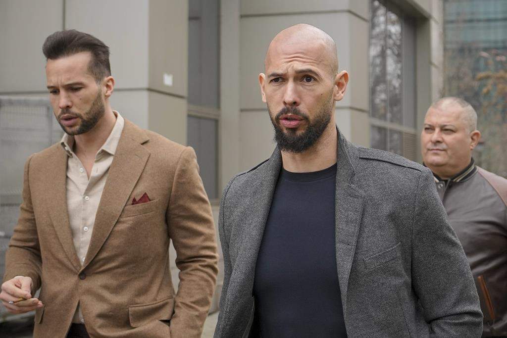 FILE - Andrew Tate, right, and his brother Tristan leave the tribunal in Bucharest, Romania, Thursday, Feb. 29, 2024.