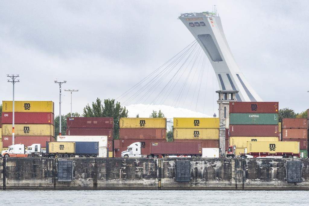 A federal tribunal says Montreal port employers have no right to make employees work during a strike, paving the way for negotiations to resume ahead of potential job action. Trucks carrying shipping containers drive through the Port of Montreal, Tuesday, Sept.19, 2023. THE CANADIAN PRESS/Christinne Muschi.