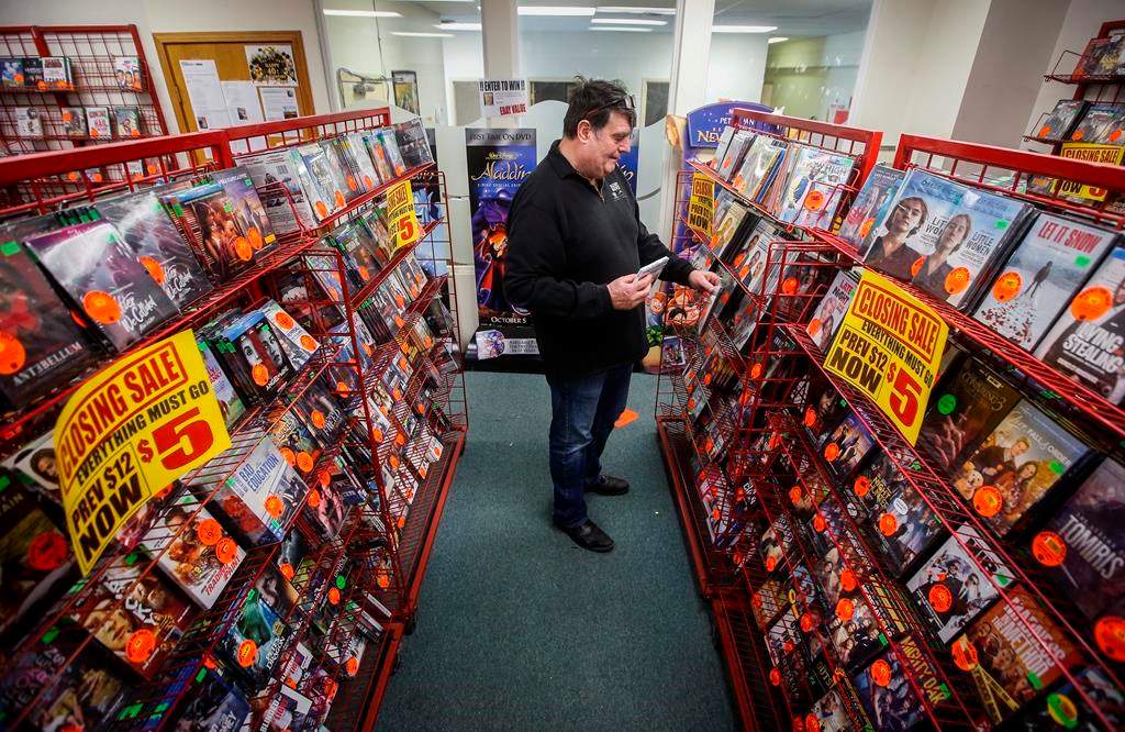 Glen Fuhl, president and CEO of Video King, is photographed as he organizes shelves in one of his stores in Winnipeg Thursday, March 7, 2024. Fuhl is planning to close up shop after forty years in the movie business. April 6 will be the day he turns off the lights for good. THE CANADIAN PRESS/John Woods.