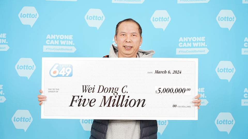 A man holding a $5 million lottery cheque.