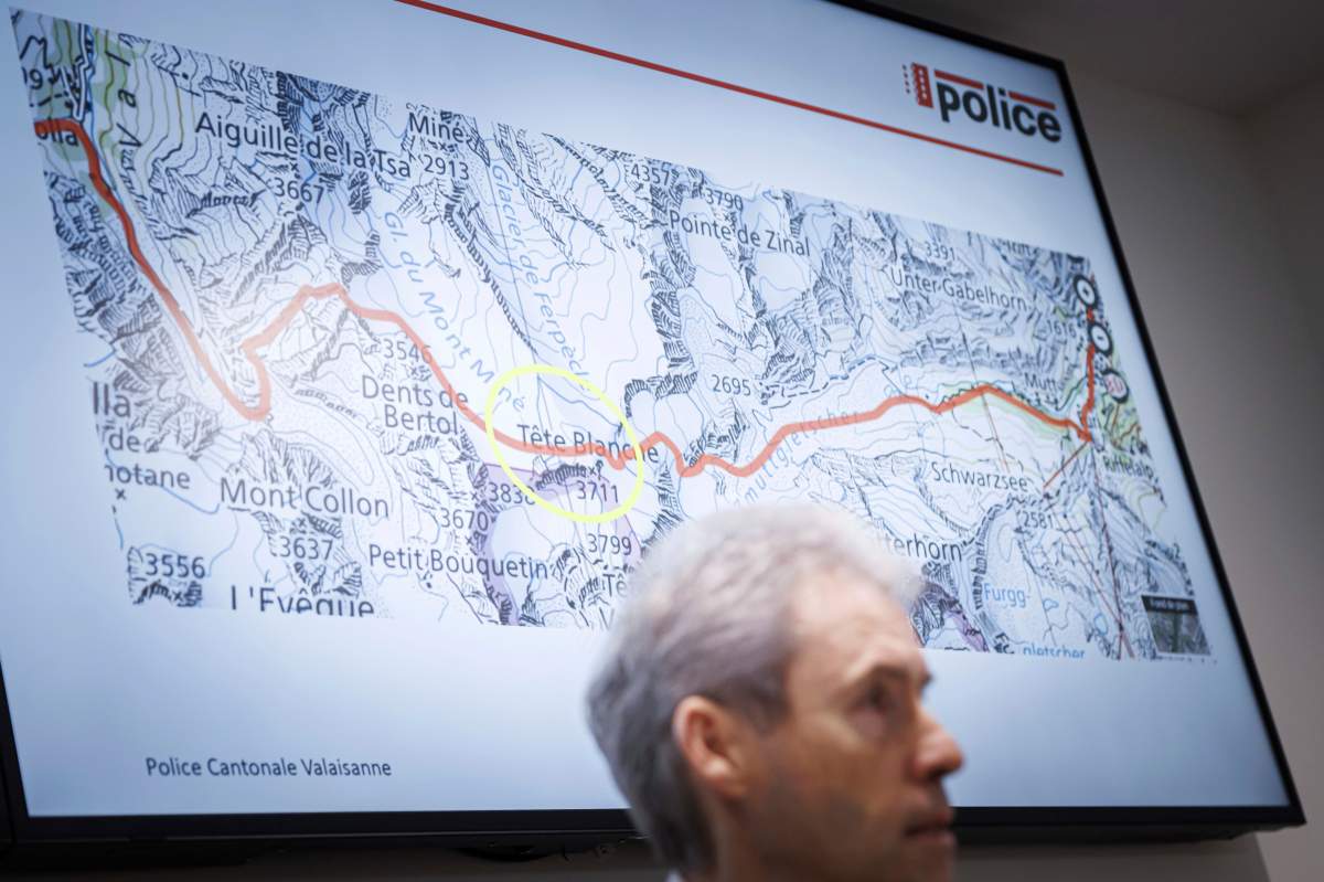Commandant of the Valais Cantonal Police Christian Varone speaks during a press conference as a map in the background shows the location where five cross-country skiers were found dead, in Sion, Switzerland, Monday, March 11, 2024.