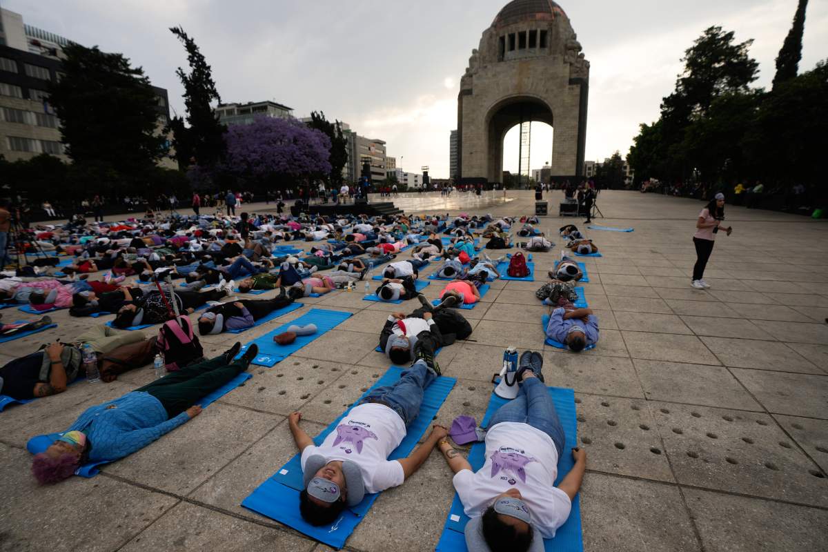 Lolling with bright blue mats, sleeping masks and travel pillows, people lie sprawled out at the base of the iconic Monument to the Revolution to take a nap, in Mexico City, Friday, March 15, 2024.