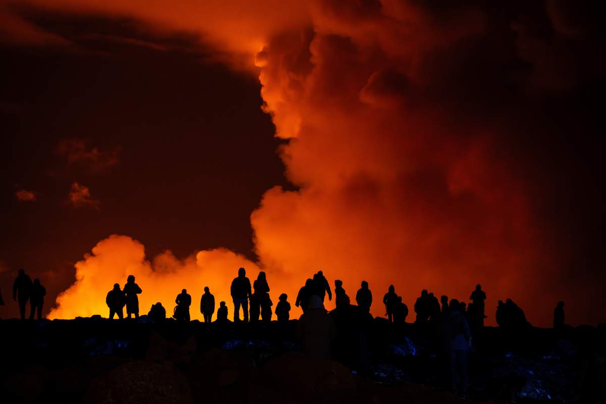 Spectators watch plumes of smoke from volcanic activity between Hagafell and Stóri-Skógfell, Iceland, on Saturday, March 16, 2024.