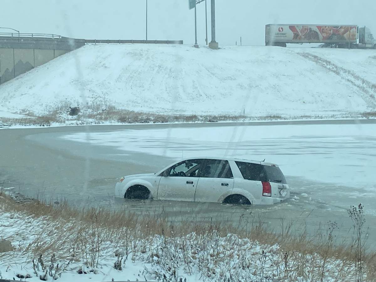 A vehicle is pictured in some water after spinning off the road in Calgary near Stoney Trail and Metis Trail N.E. on March 20, 2024.