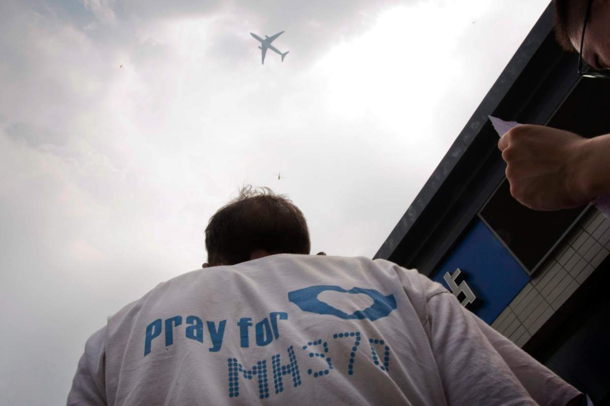 A relative of Chinese passengers onboard the missing Malaysia Airlines Flight 370 wore a t-shirt that reads "Pray for MH370."