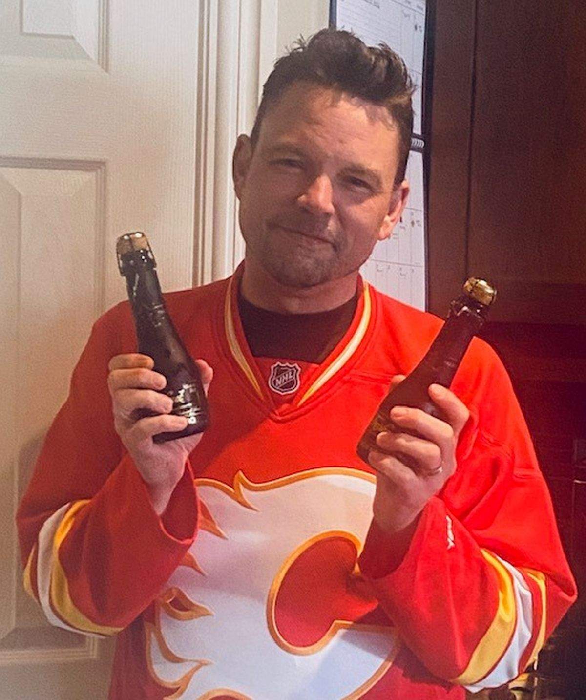 Shane Bycuik with the two champagne bottles he's had since 2004, waiting for the Calgary Flames to win the Stanley Cup before he opens them.
