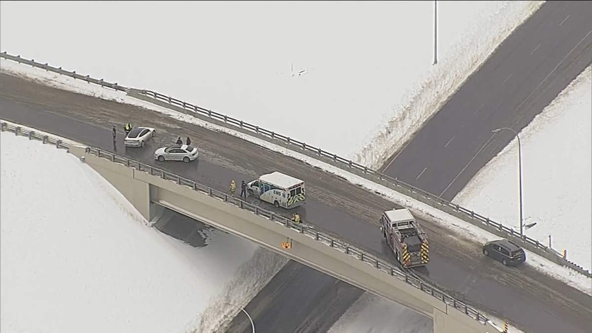 Emergency vehicles attend to a collision on a slippery bridge deck in Calgary on March 20, 2024.