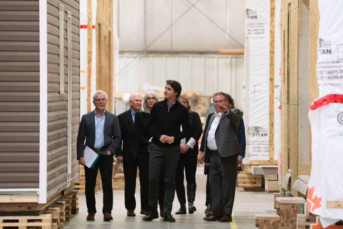 Prime Minister Justin Trudeau is guided on a tour by Bill Boulton, president of Smart Modular Canada, ahead of a 20.7 million dollar announcement in federal funds for new homes to be built at the factory in Thunder Bay, Ont.