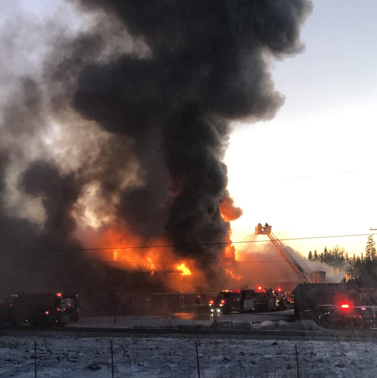 Fire crews arriving at the scene of a large fire at the Covered Bridge Potato Chips factory in Hartland, N.B., on Friday evening. Submitted by Riki-Lynn Dickinson.